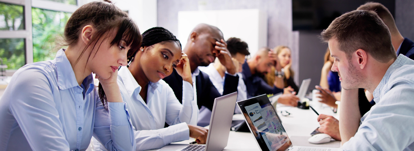 Stressed office workers staring at their computer screens